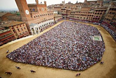 Piazza del Campo during the Palio, packed with spectators.