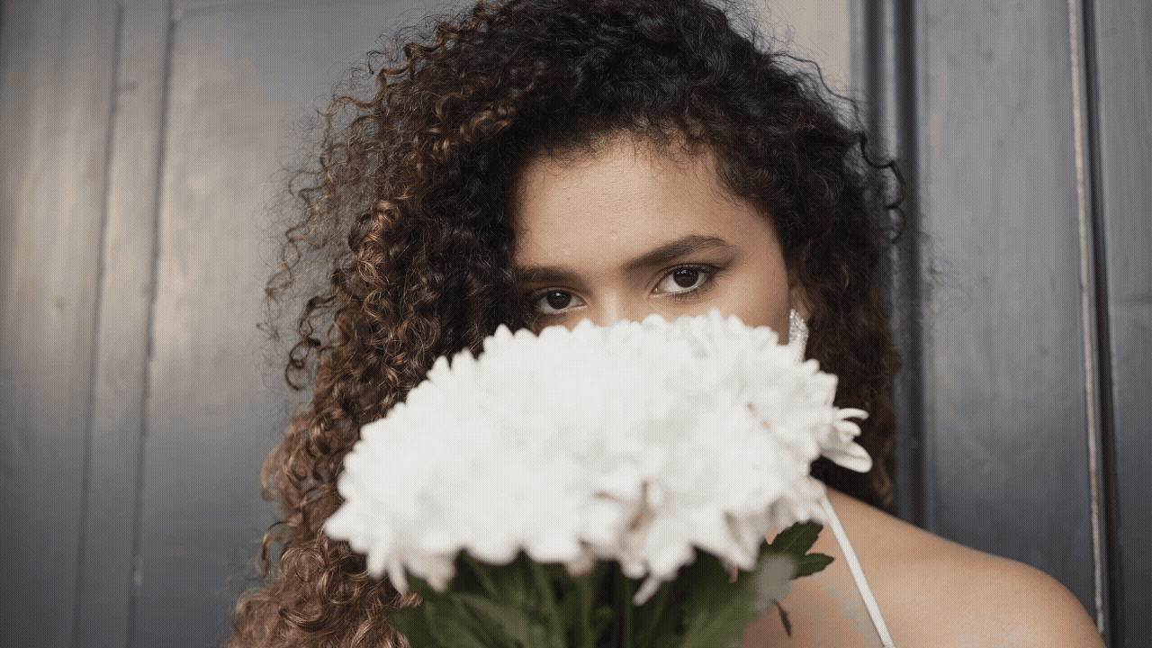 Frau mit Blumen an der Nase zum Riechen der Duftstoffe