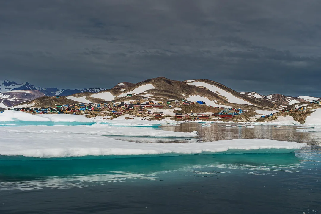 Ittoqqortoormiit, one of Greenland’s most remote towns, seen beyond sea ice near the entrance to Scoresby Sund in northeast Greenland.