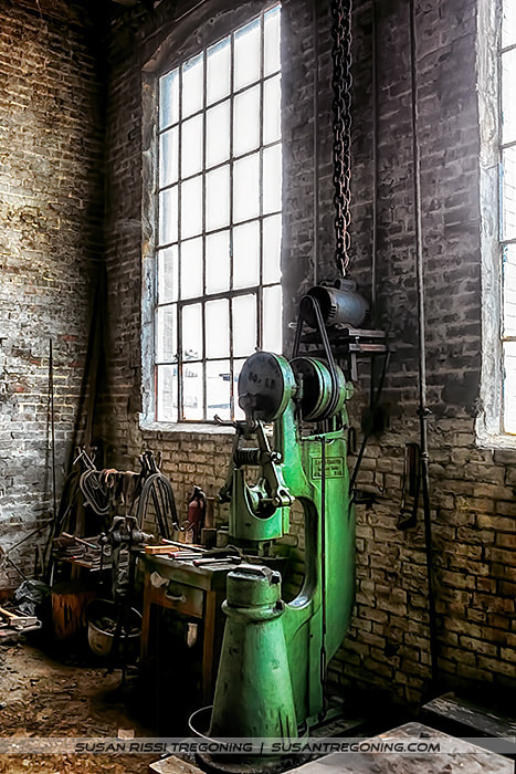 The Little Giant power hammer anchors this corner of the Soule Steam Feed Works shop, its cast‑iron frame and worn surfaces echoing decades of blacksmithing and steam‑era craftsmanship.