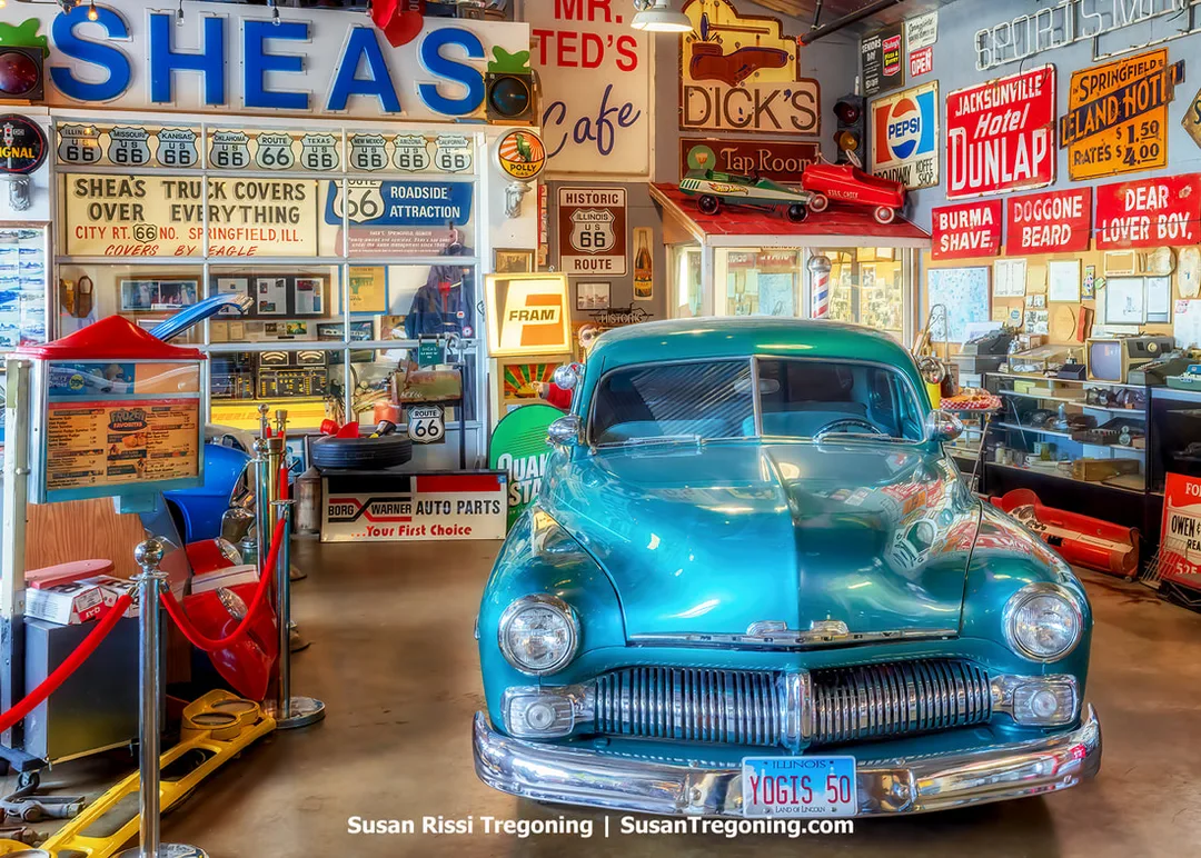 A 1950 Mercury Coupe is on display inside the Motorheads Museum at Motorheads Bar & Grill in Springfield, Illinois. The car is surrounded by Historic Route 66 memorabilia and additional automotive displays.