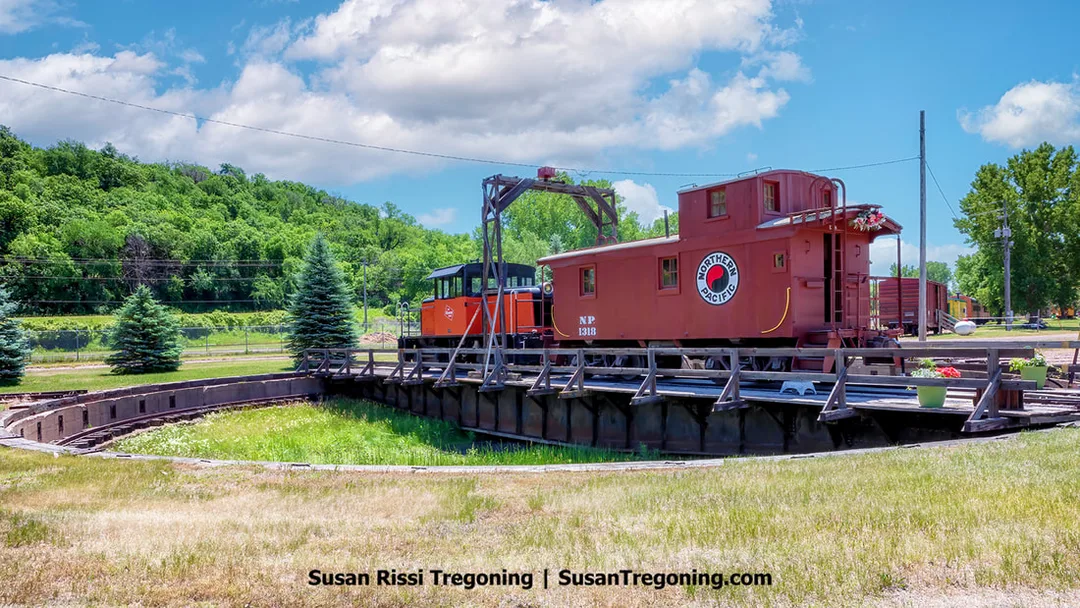 A view of the historic railroad turntable at the Sioux City Railroad Museum in Sioux City, Iowa. The structure is part of the Milwaukee Railroad Shops Historic District, showing the circular pit and central bridge used to rotate locomotives.