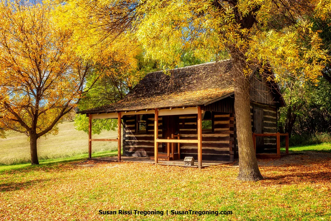 Historic Andrew Sunne Cabin at the Sunne Demonstration Farm in Fort Ransom State Park, a restored Norwegian immigrant homestead surrounded by autumn trees in the Sheyenne River Valley of North Dakota.