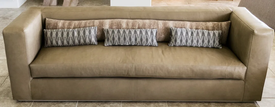 Leather sofa upholstered for private client in La Quinta and pillows in a horse like fiber finish that is faux and customers own material