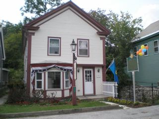 Image of the Mill Brook House that was lost in Irene in 2011. White, two story house, with red border.