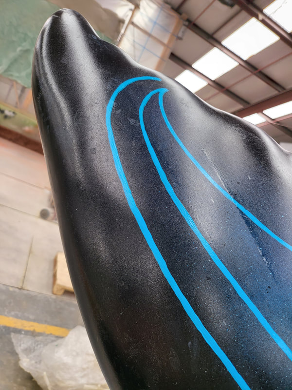 Finished black “Kāpehu Whetū” whale-tail sculpture with blue artwork