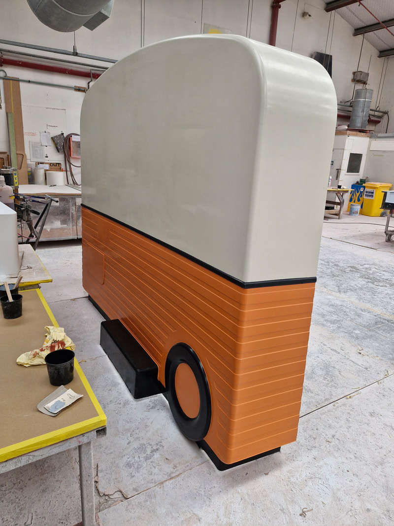Side view of an MRI caravan shell with orange lower panels