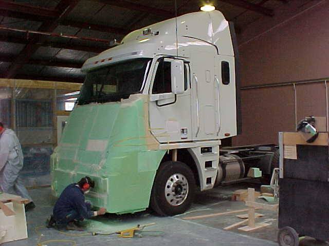 Worker shaping a full-size truck-front mock-up in the FDL workshop