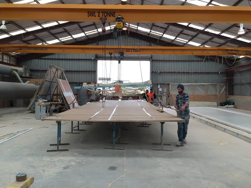Workers attaching lifting hooks to a completed fibreglass panel before loading it onto a PTS truck