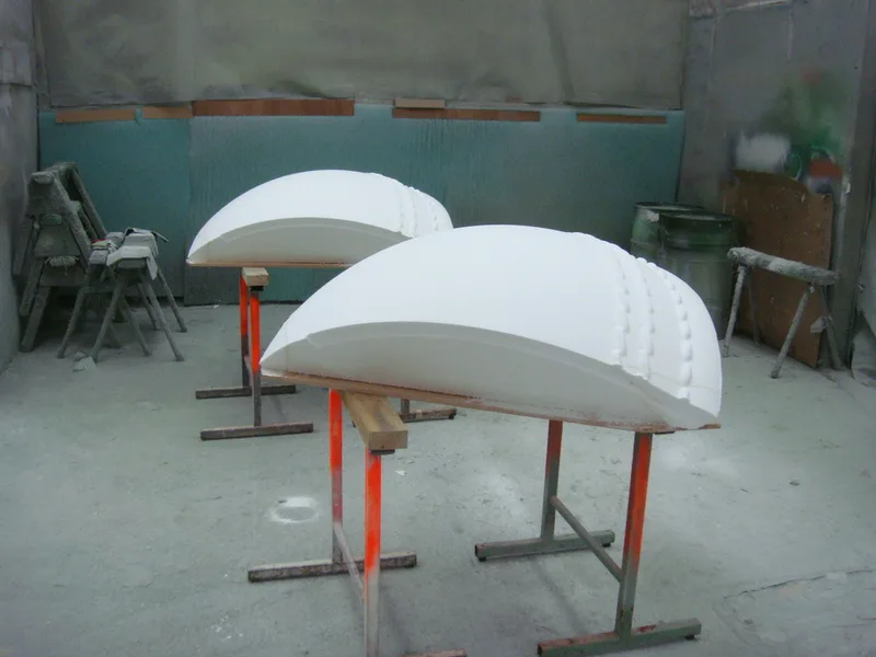 Two completed fibreglass cricket-ball quarter-shells before assembly