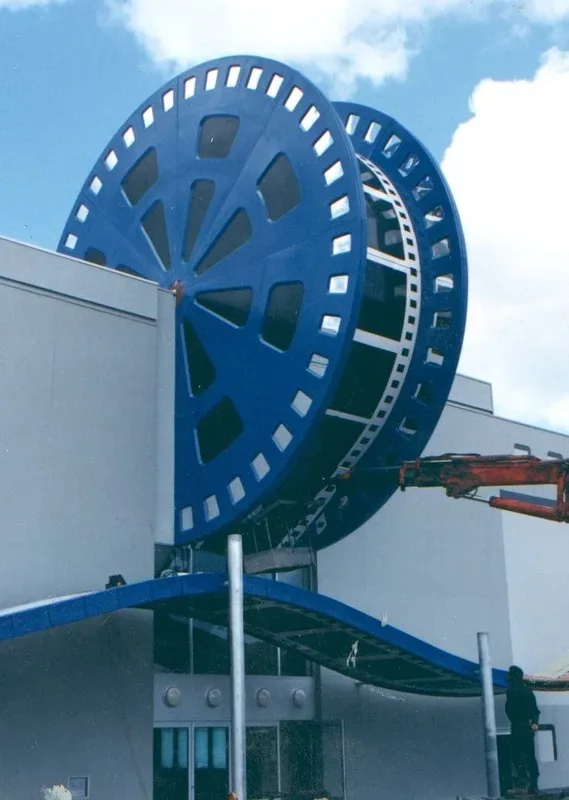 Large blue fibreglass film reel installed above a building entrance