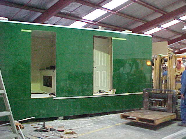 Green Super Loo exterior during door and wall-panel installation