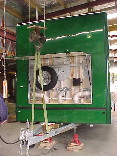 Open Super Loo service compartment showing plumbing and the spare wheel
