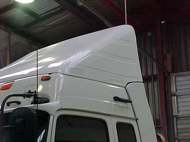White Breeze Busta wind deflector fitted above a truck cab