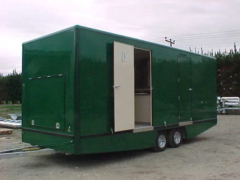 Green tandem-axle fibreglass mobile unit with side access door