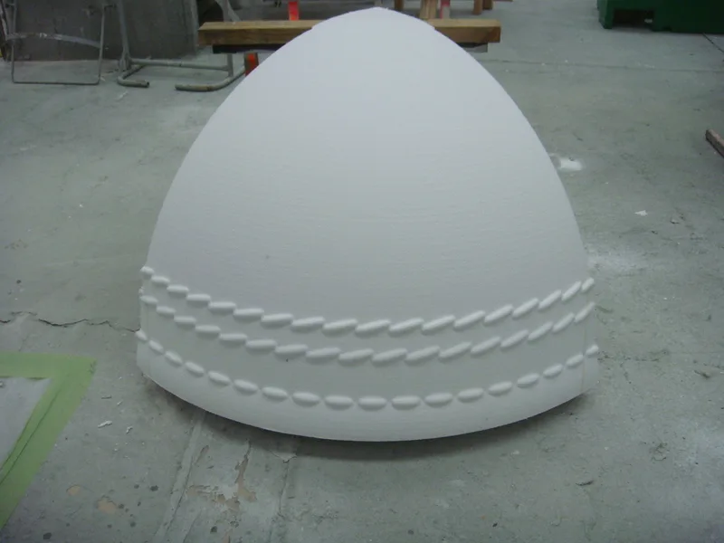 Unfinished cricket-ball quarter-shell showing its raised seam detail