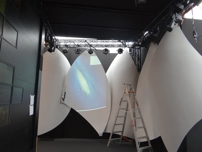 Installer working on the central sail-shaped projection screen