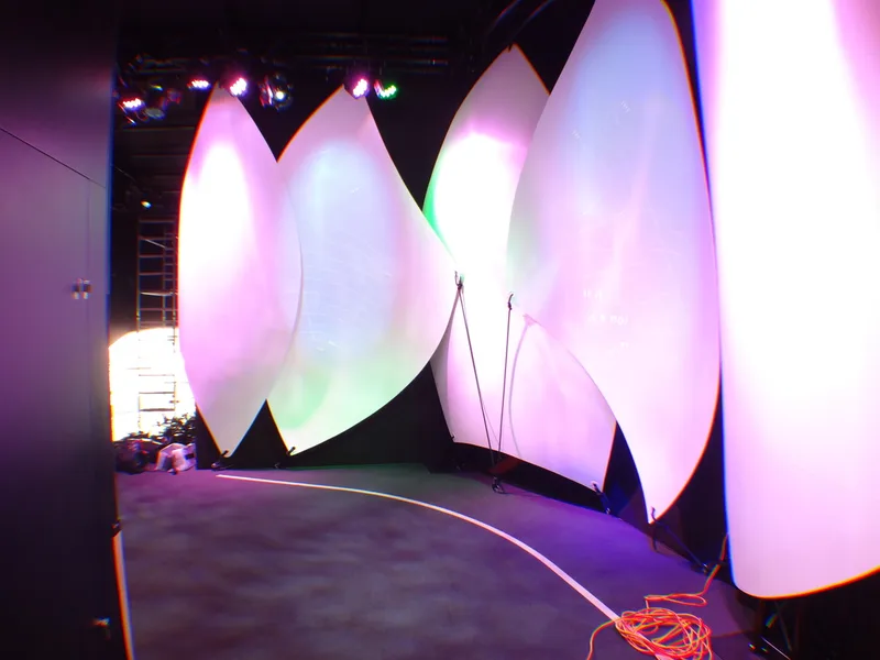 Group of moulded sail forms illuminated in pink and green