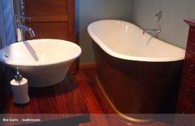 White freestanding French Tub-style composite bath in a timber-lined bathroom