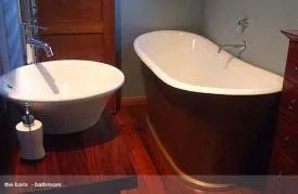 White freestanding French Tub-style composite bath in a timber-lined bathroom