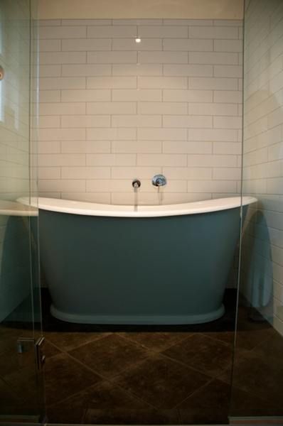 Blue composite bath in a tiled bathroom