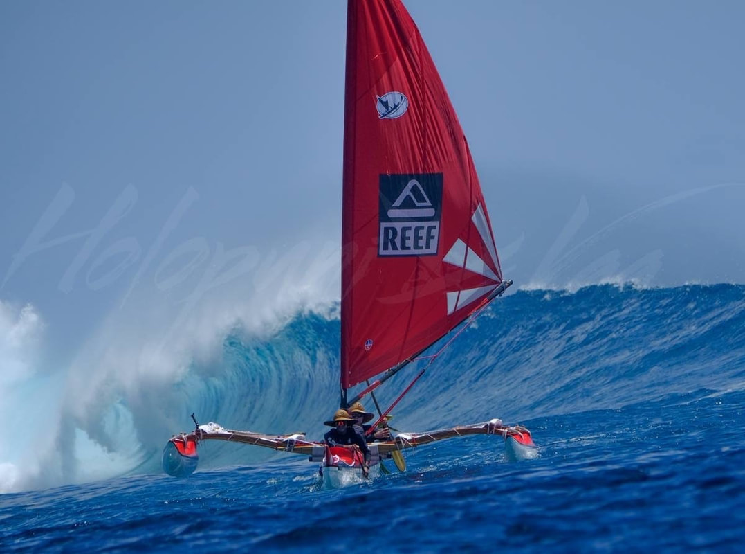 Holopuni sailing canoe riding a wave in Tahiti