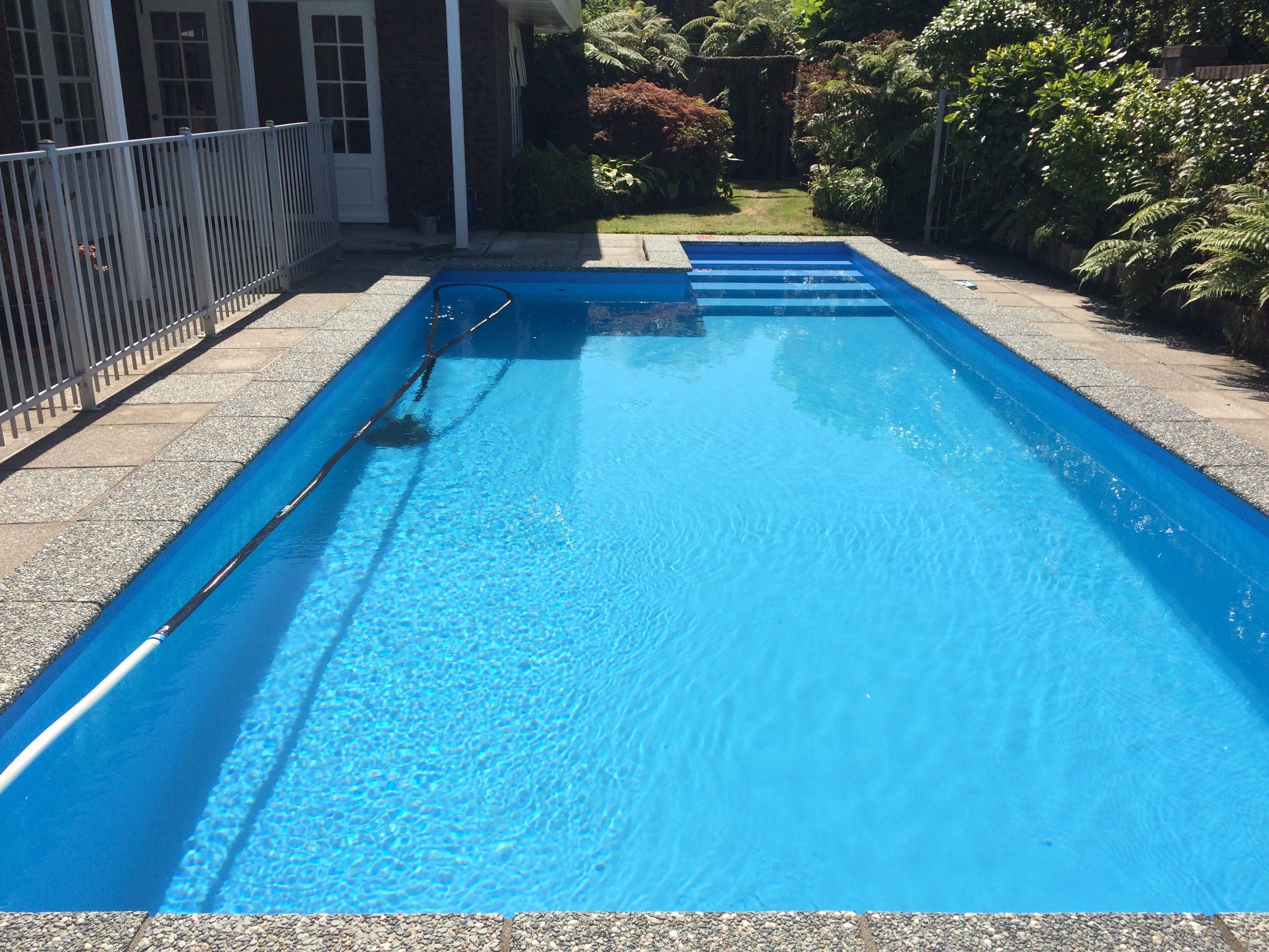 Long rectangular fibreglass swimming pool beside a home