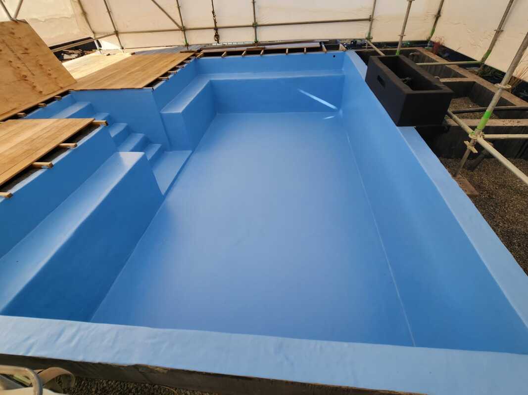 Blue fibreglass pool shell during manufacture
