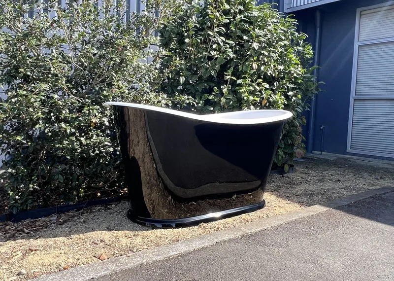 Black and white composite bath outdoors beside a building