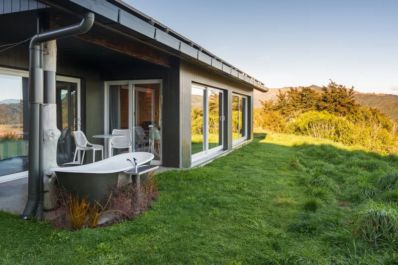 White outdoor composite bath beside a rural house