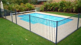 Black steel safety fence surrounding an outdoor swimming pool