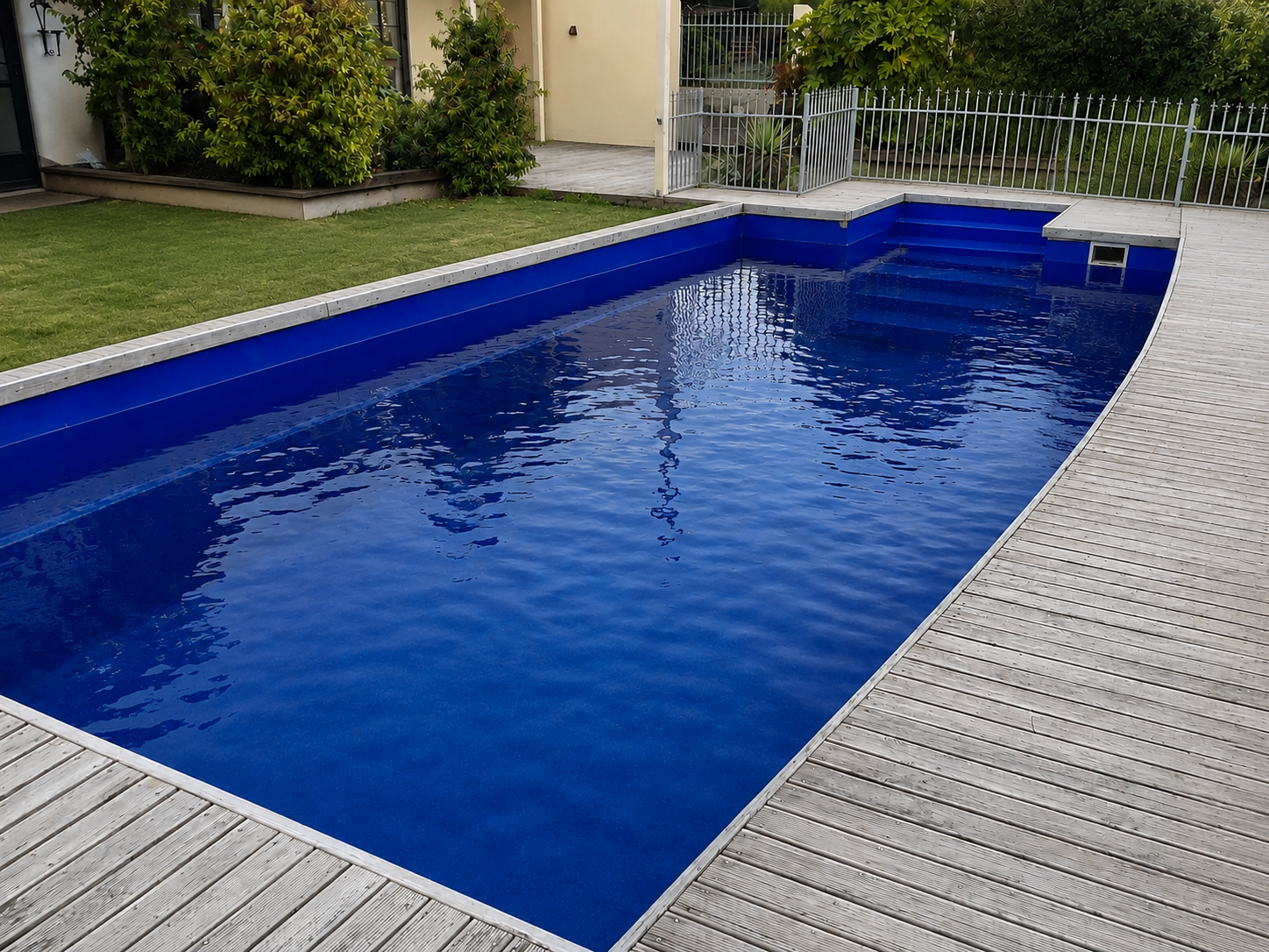 Dark blue rectangular fibreglass swimming pool with a timber deck