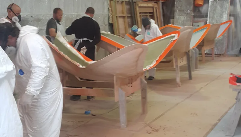 Workers trimming fibreglass whale-tail sculptures in the FDL workshop