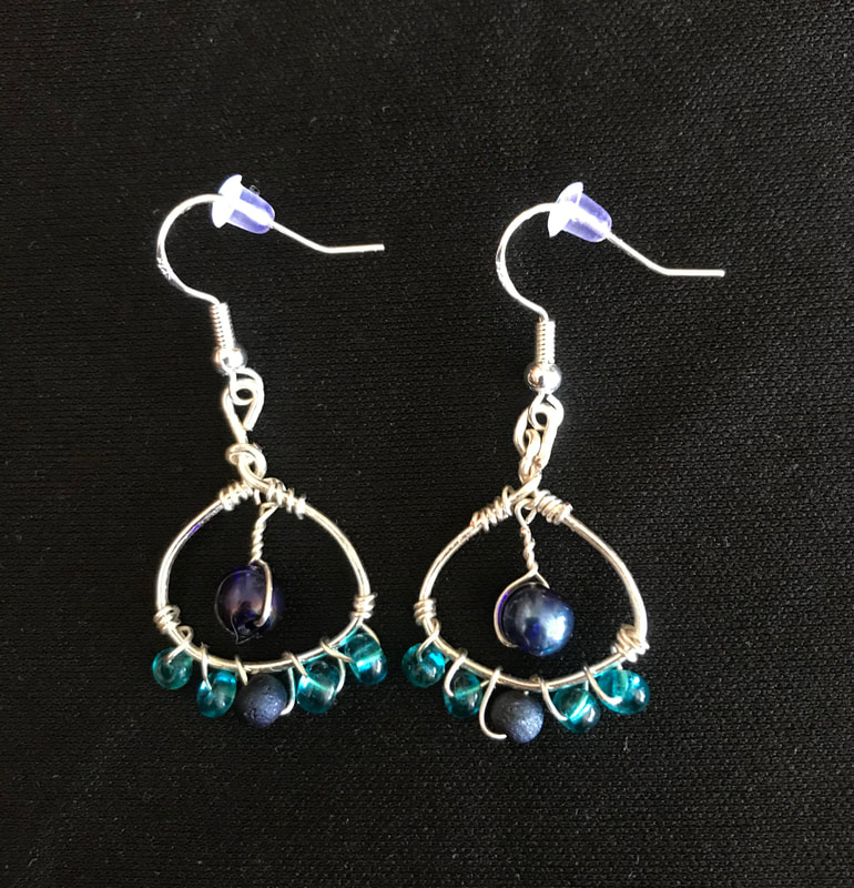 silver metal shaped earring with wirewrap and blue beads