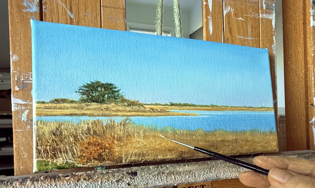 A radiant, small, oil painting of the sun rising over the Atlantic ocean, the sky gradually going from blazing on the horizon to deep blues, all reflected in a tidal pool in the foreground sand.