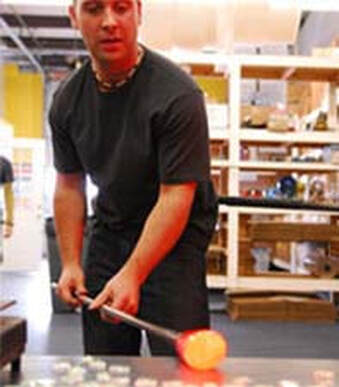 Luke Adams blowing glass.