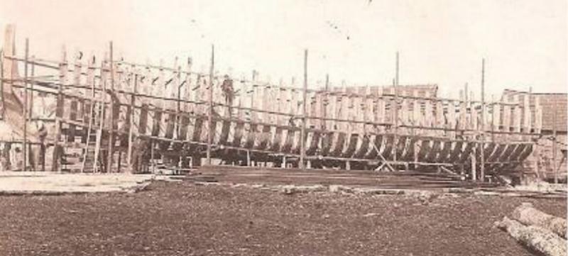 Old sepia photograph of the skeletal beginnings of a schooner in Sussex County, Delaware, in the late 1800s.