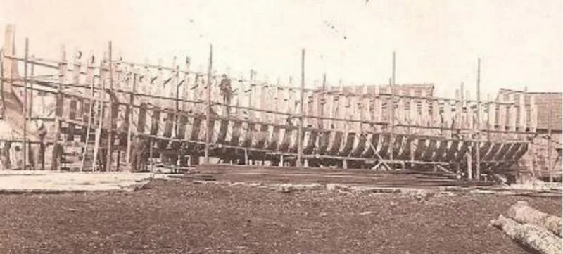 Old sepia photograph of the skeletal beginnings of a schooner in Sussex County, Delaware, in the late 1800s.