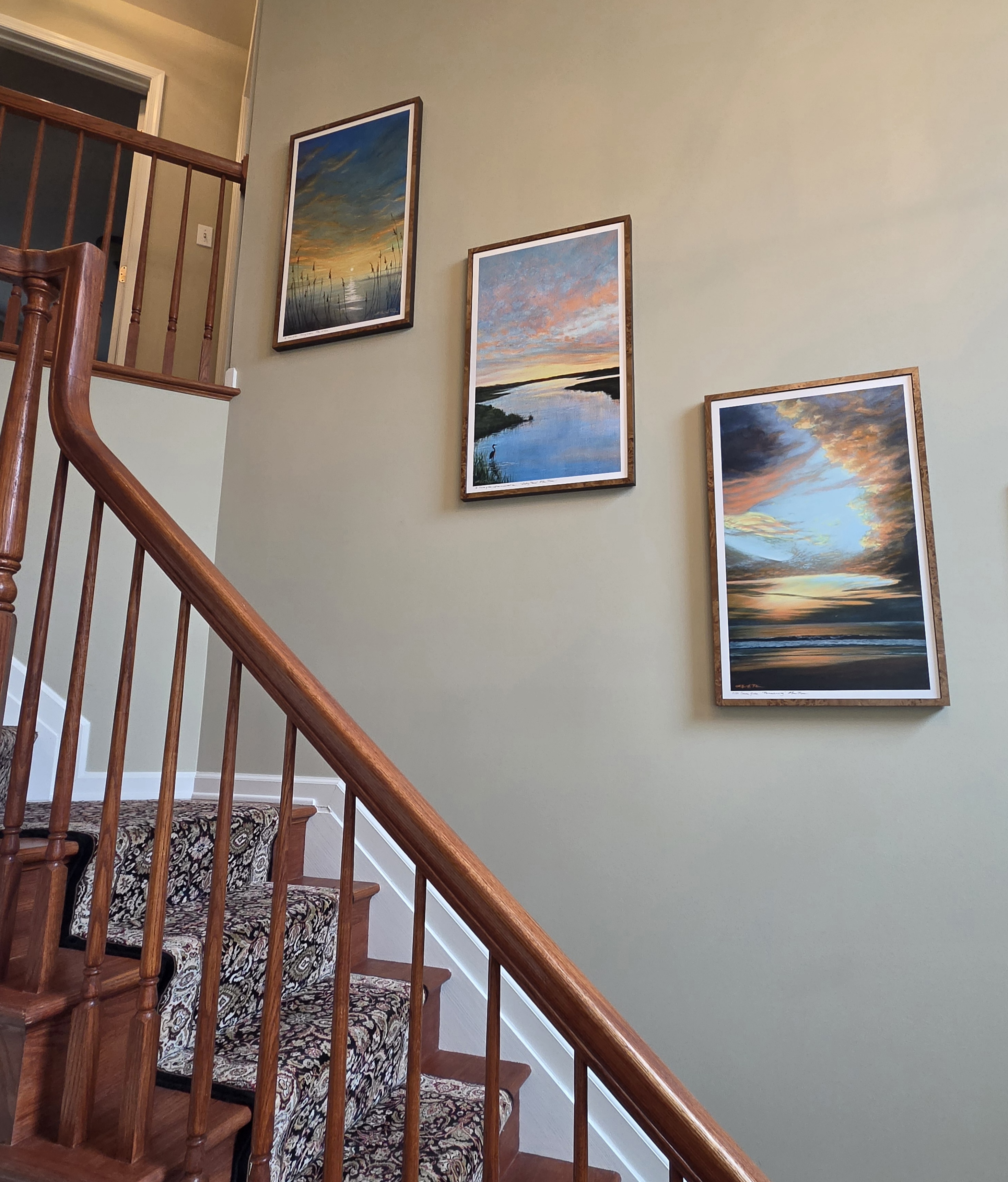 Photo of three custom canvas reproductions of Ellen Rice paintings arranged on client's wall and cathedral ceiling on stairs.