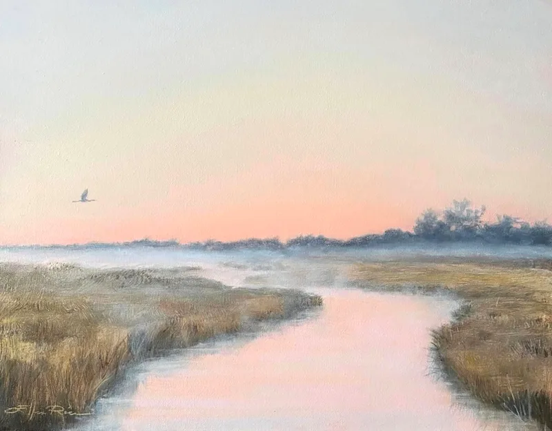 A Great Blue Heron rises from the mist and flies toward sunrise over the marshes and waterways of southern Delaware's back bay area.
