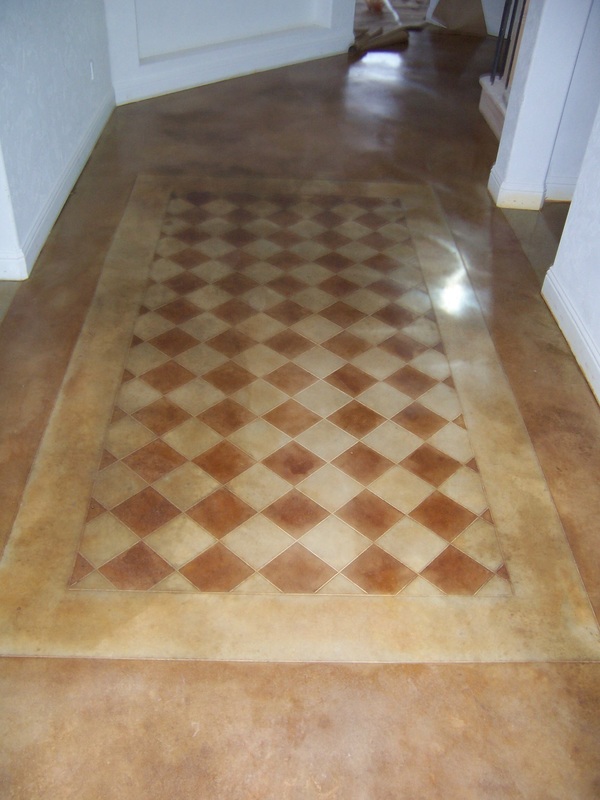 Scored and hand stained concrete floor rug design