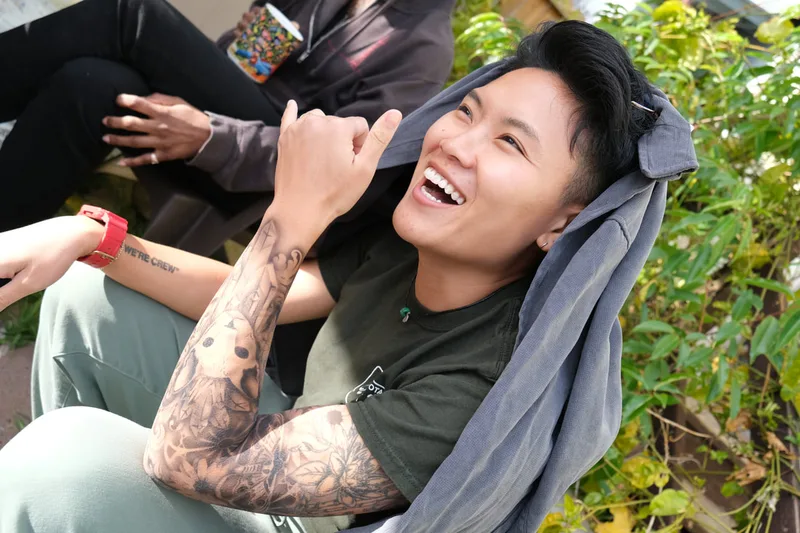 A smiling asian person modeling a full sleeve of realistic airbrush tattoo's in Mountain View, California