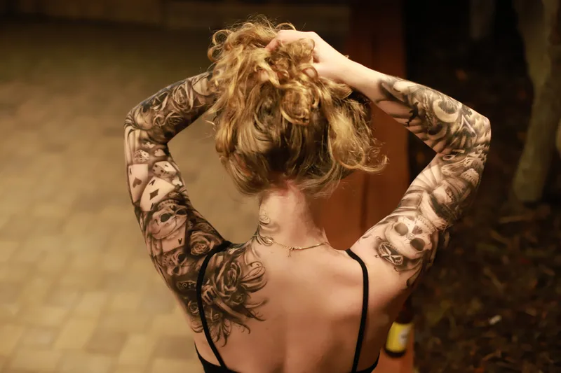 a young white woman with blonde hair modeling two full sleeves of waterproof airbrush tattoo's in San Rafael, California