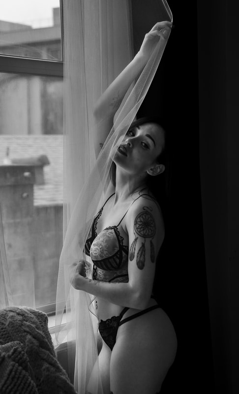 A woman in a boudoir photoshoot wearing body paint that looks like red and black lingerie in the SF Bay area