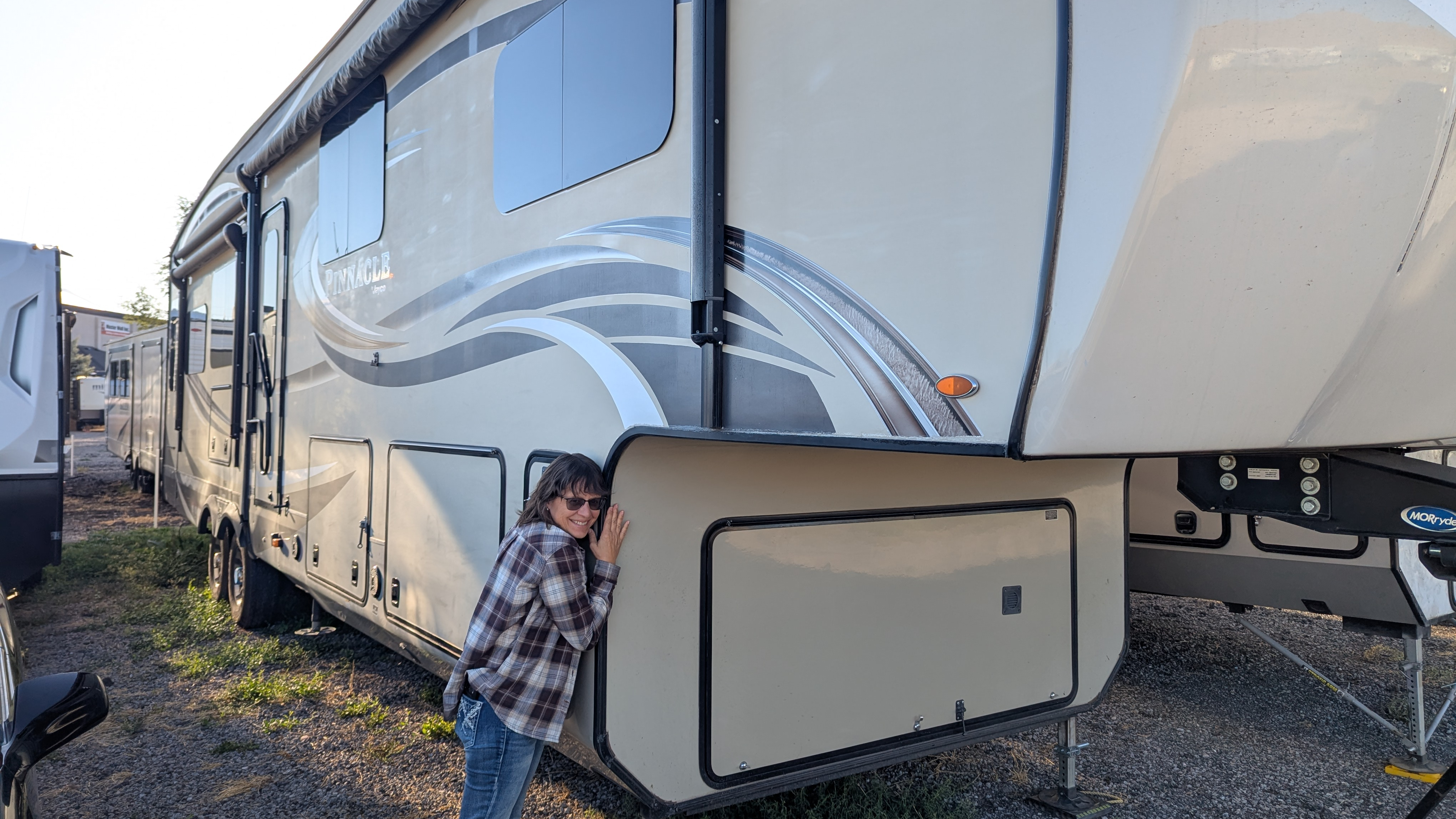 Woman hugging a fifth-wheel RV
