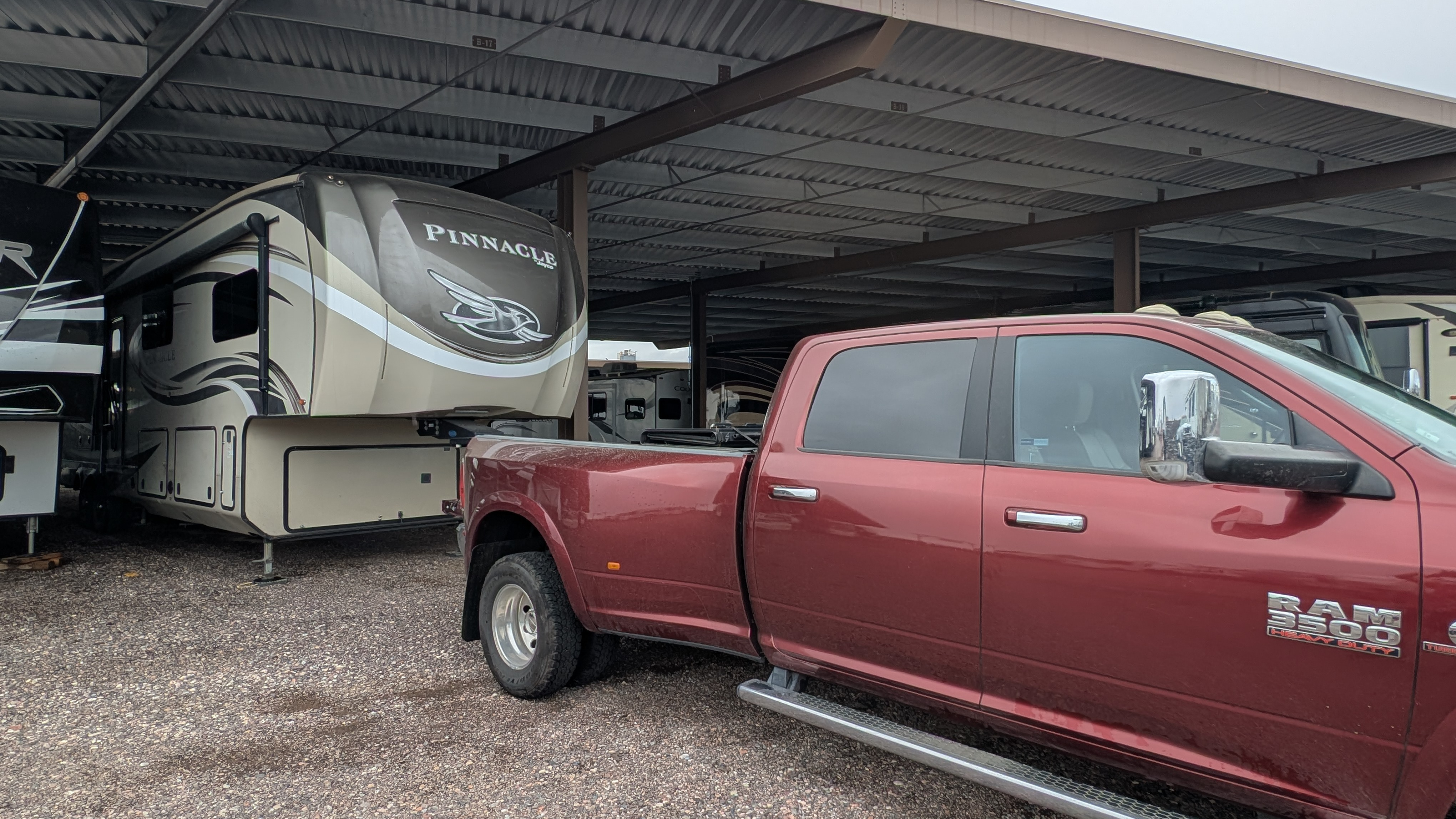 A Dodge Ram 3500 dually in front of a Jayco Pinnacle fifth wheel at an RV storage lot