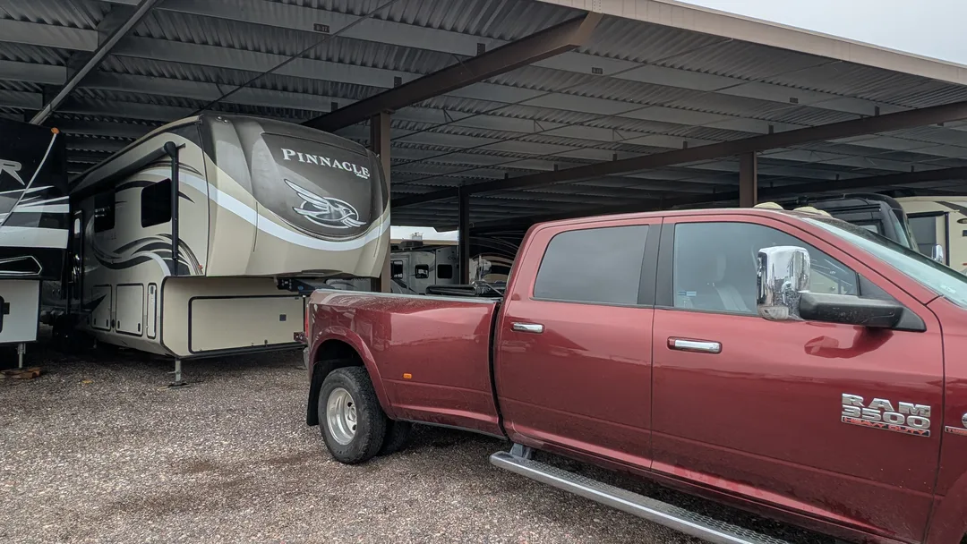A Dodge Ram 3500 in front of a Jayco Pinnacle fifth wheel at an RV storage yard