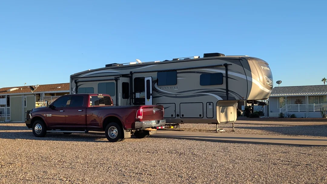 A truck and fifth wheel on a gravel lot