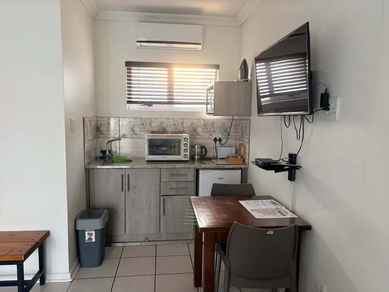 Kitchenette, table and TV in Room 7 at The Solomon Edwardian Guest House