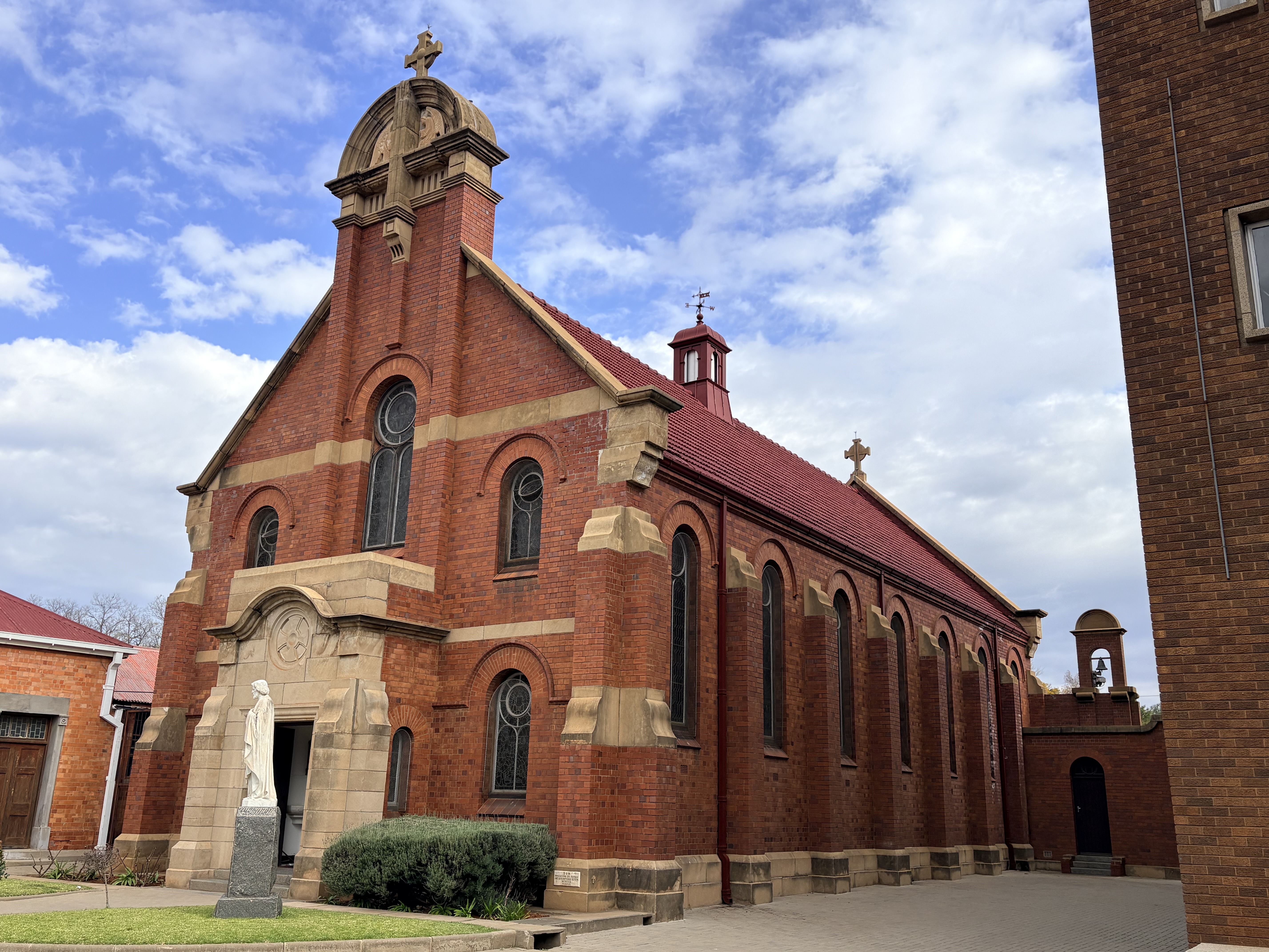 Exterior of the College Chapel at St Patrick's CBC in Kimberley, showing the red-brick chapel building with arched windows and its main entrance.